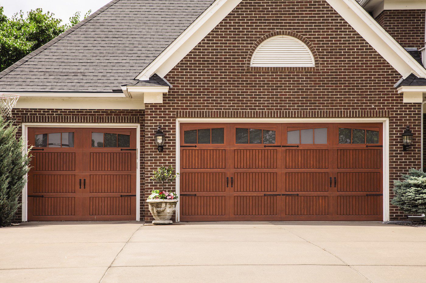 Impression Fiberglass Collection® Garage Door by the Overhead Door Company - Color is of cherry wood. The home is dark brown brick.