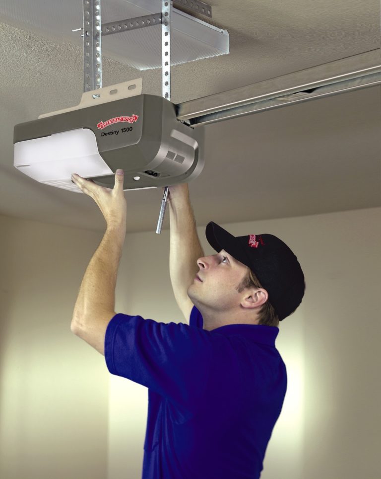 Overhead Door Installer putting up an opener and making a garage door repair.