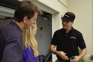 Garage Door Technician Explaining Why a Garage Door Is Opening By Itself 