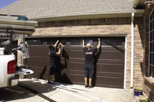 Installers hanging a new garage door.