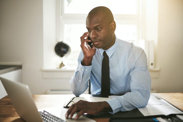 Businessman talking on the phone and working on a laptop