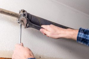 using tools for a garage door spring repair in Madison Alabama