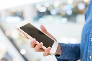 Lady holding a computer tablet while searching for the best garage door company in North Alabama to service her garage door. She is studying the troubleshooting guide from Overhead Door™.