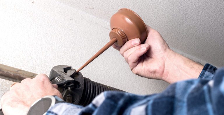 Replacing broken garage door spring placing oil and making adjustments