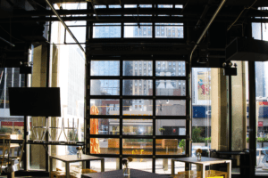 Aluminum-Model 521-Black powdercoat Commercial overhead garage door installed on an old building downtown. The door is very tall and black in color.