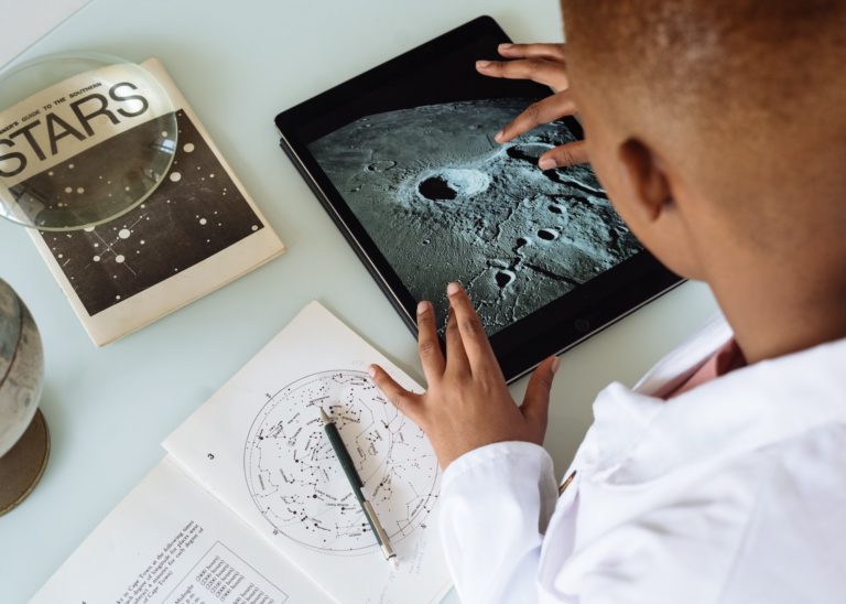 Huntsville, Alabama is a great place to live. Image of a student working on an iPad studying the moon and stars. Huntsville, Alabama placing high focus on this in their free public schools.