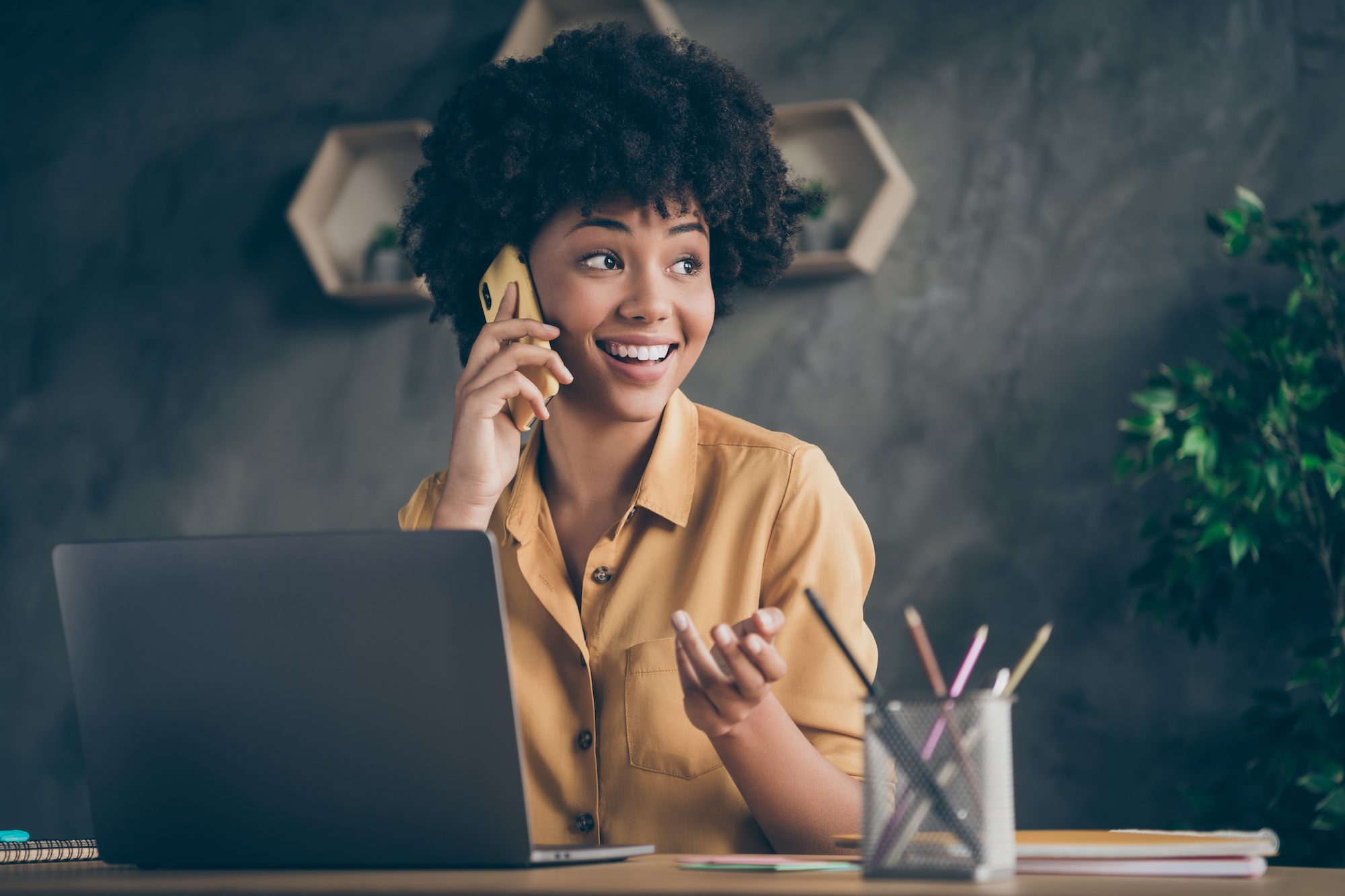 A lady happily sitting at her desk in conversation about a garage door