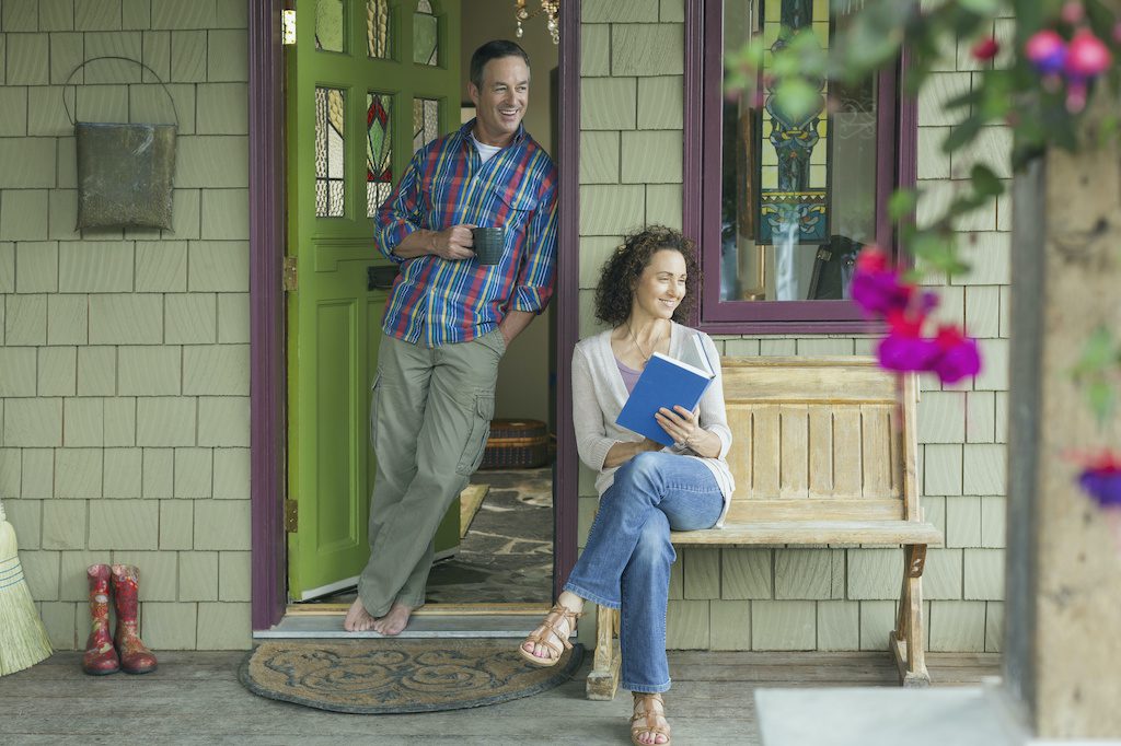 Couple sitting on a front porch happy