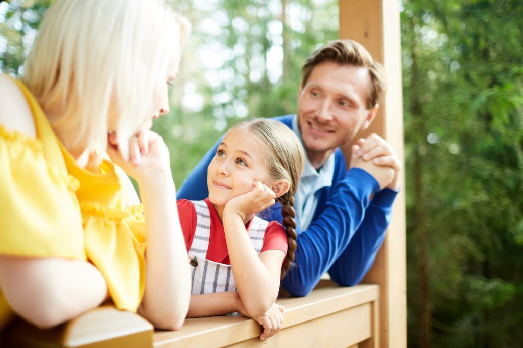 A family sitting on the front porch enjoying the day in Athens, Alabama.
