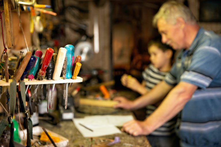 Grandfather in garage with grandson trying to troubleshoot why is garage door will not open.