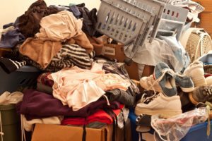 Declutter your garage is one of the 20+ Safety tips for keeping your garage cooler. Homeowner here has left a pile of clothes that doesn't allow for proper airflow.